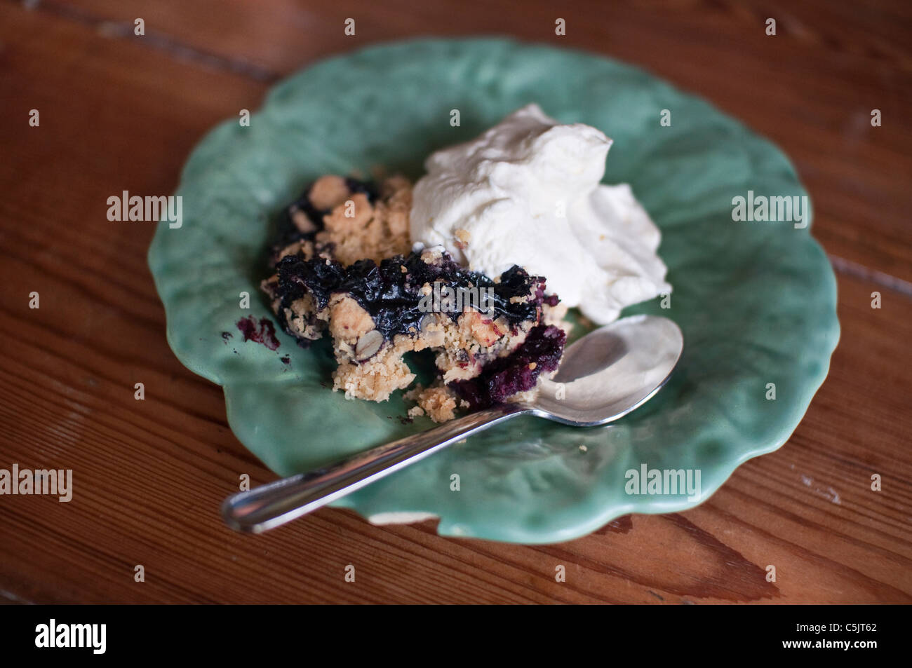 Crumble de myrtilles, également connu sous le nom de blueberry crisp servi avec de la crème fouettée. Banque D'Images
