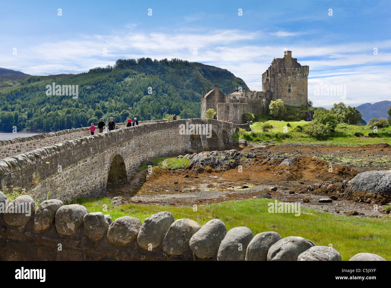 Touristes traversant le pont pour le château d'Eilean Donan, Loch Duich, Highland, Scotland, UK Banque D'Images