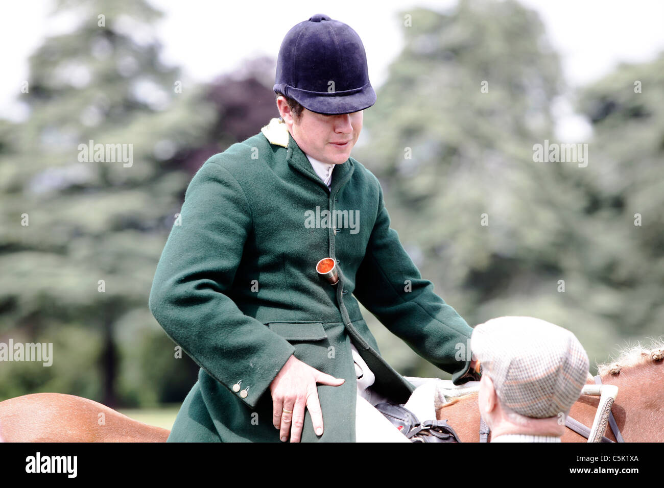 Un chasseur à cheval portant un manteau vert chats à un supporter portant une casquette à la CLA Game Fair, Blenheim Palace, nr Oxford Banque D'Images