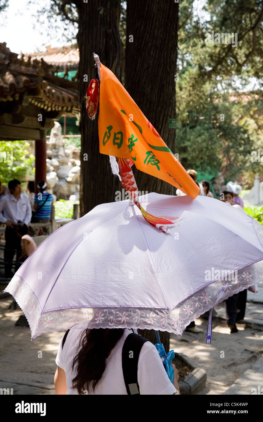 Guide de voyage chinois / leader avec drapeau parapluie & tourist / Tourisme / Visite de groupe de travail, dans la Cité Interdite à Beijing, Chine. Banque D'Images