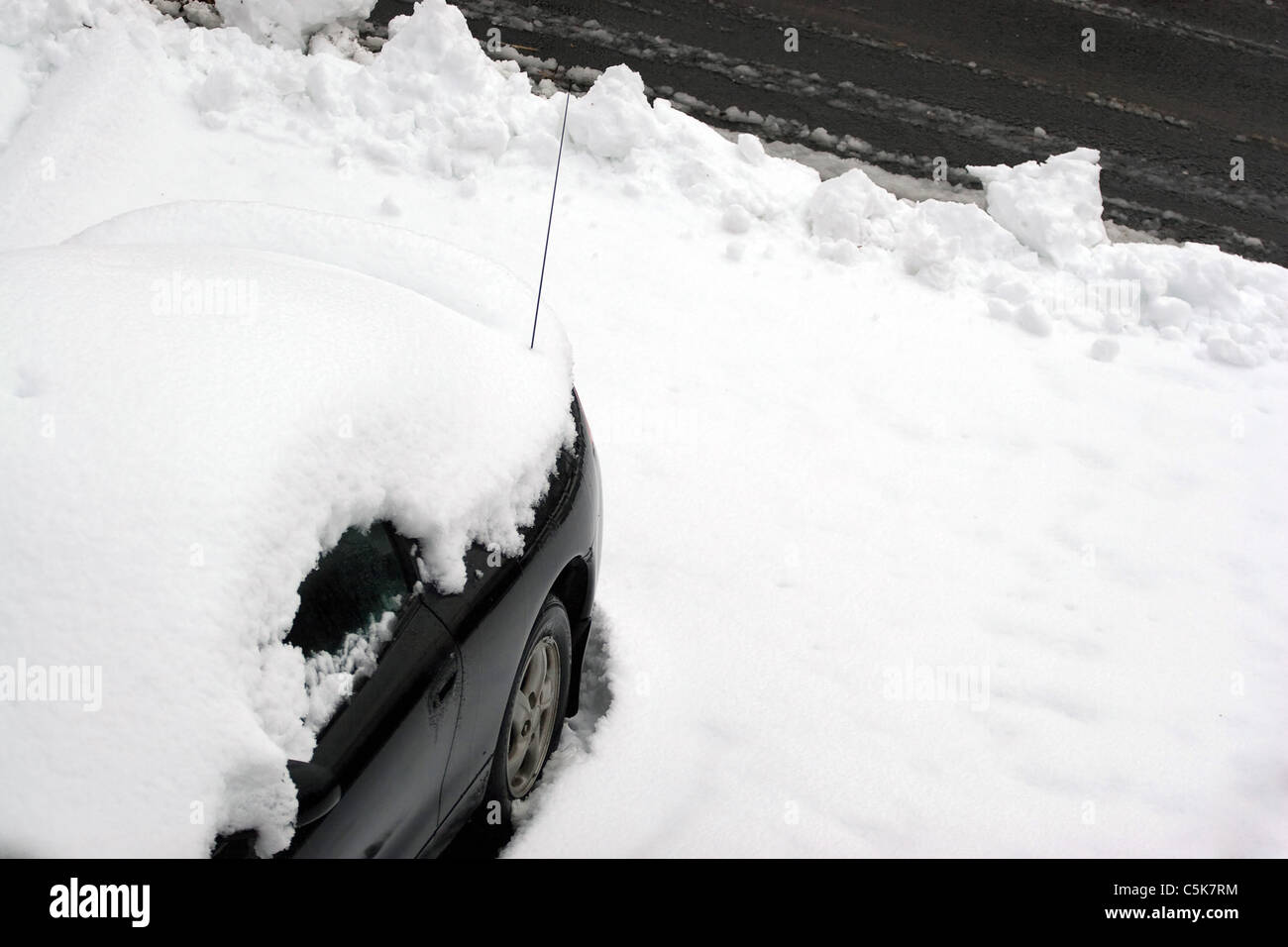 Un véhicule couvert de neige et de neige juste après la ville charrue adoptée l'allée. Banque D'Images