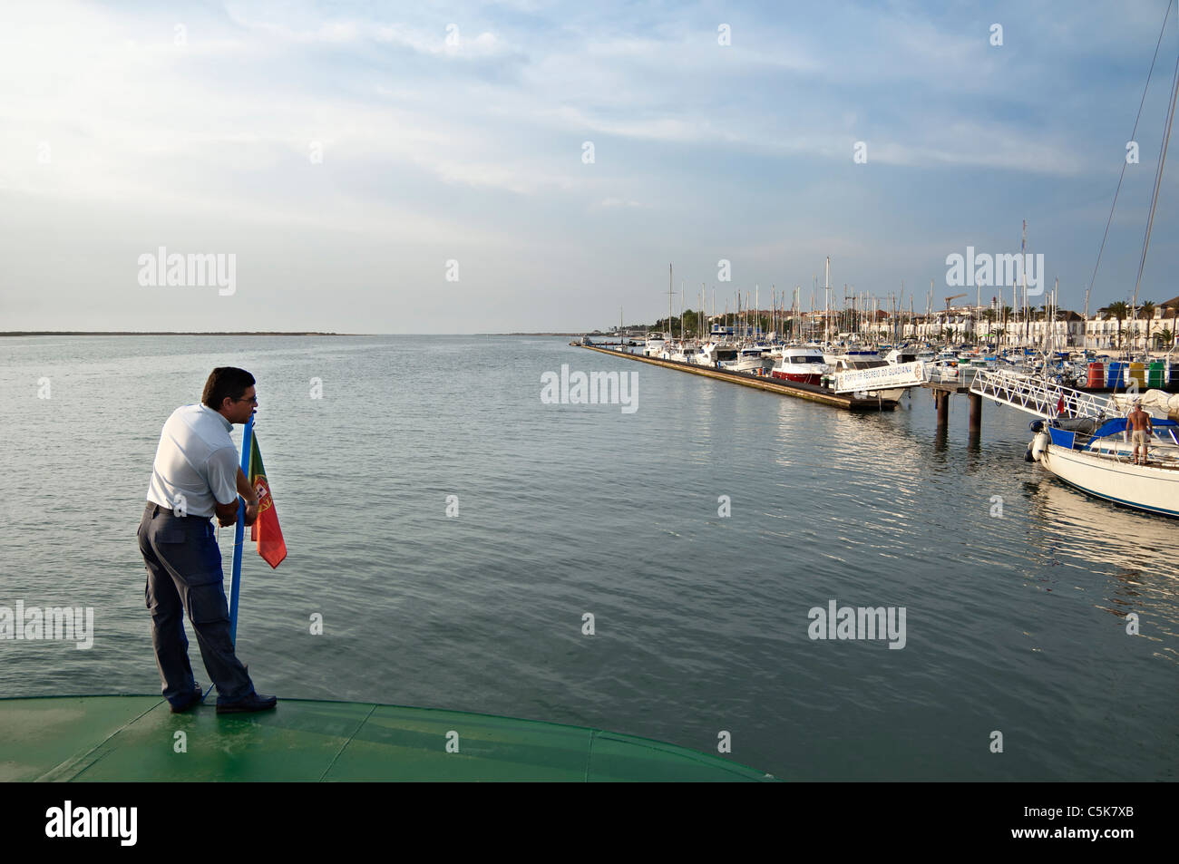 Levage de l'homme un drapeau dans le pont d'un ferry dans la rivière Guadiana, Vila Real de Santo António, Algarve, Portugal Banque D'Images