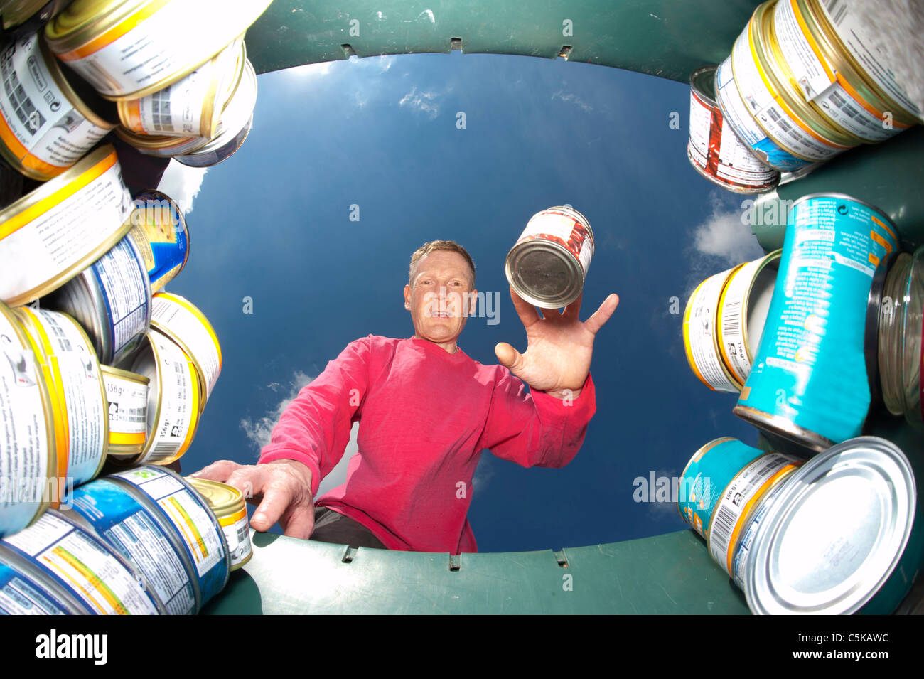 Man throwing metal peut en bac de recyclage pour le recyclage vert Banque D'Images