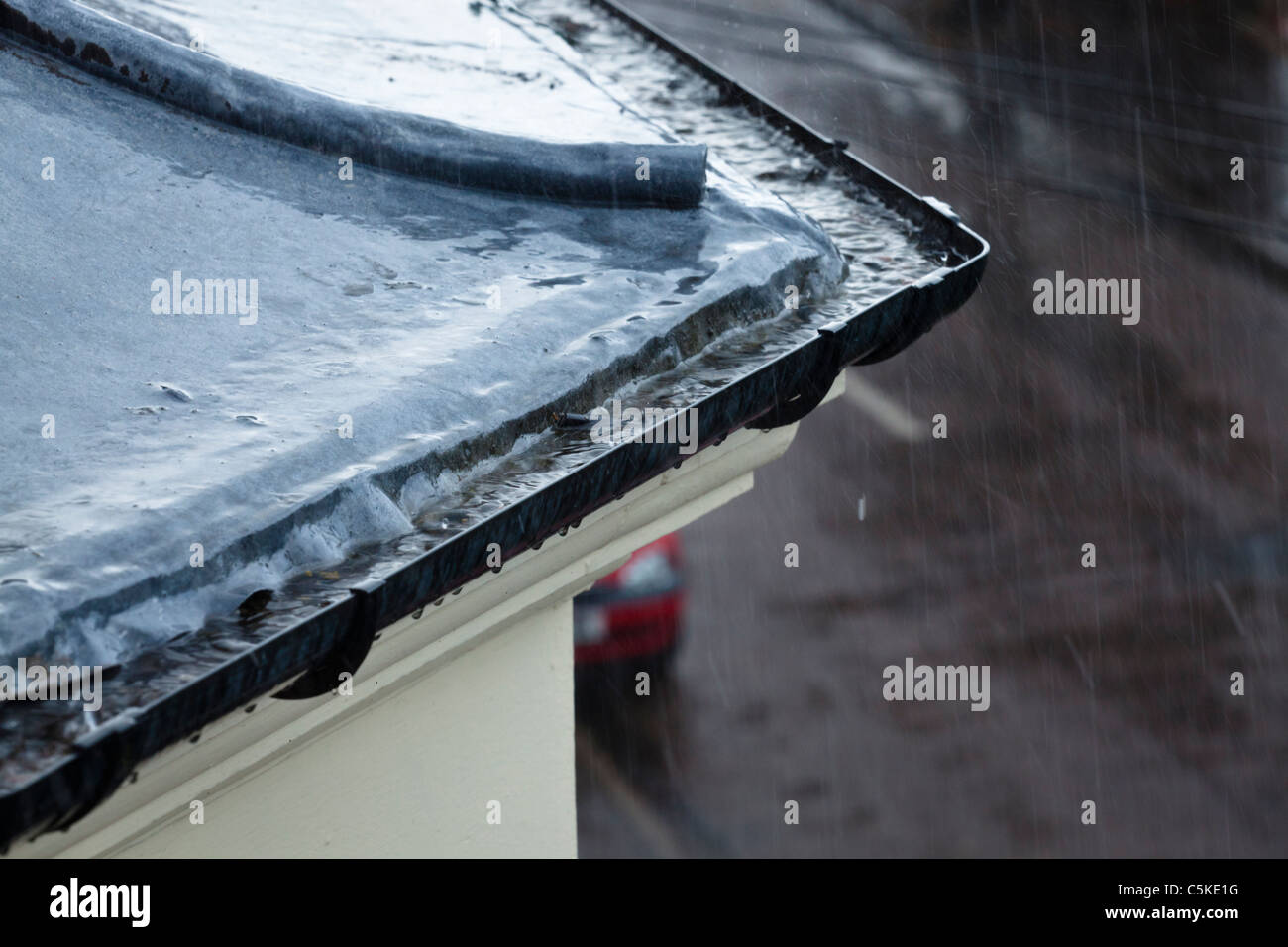 Par temps humide. La forte pluie qui tombe sur un toit et gouttières dans une rue avec en arrière-plan, Lancashire, England, UK Banque D'Images