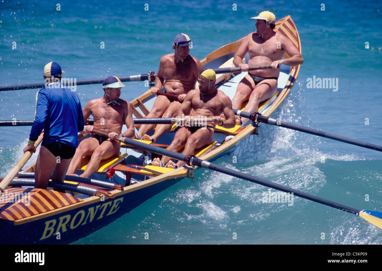 Bateau de sauvetage sur plage avec cinq hommes de partir sur une vague à Bondi Beach, Sydney, Australie Banque D'Images