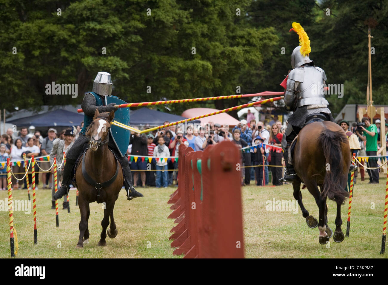 Deux chevaliers en armure sur le galop des chevaux bruns dans un tournoi de joutes, une lance, rupture, Nouvelle Zélande Banque D'Images