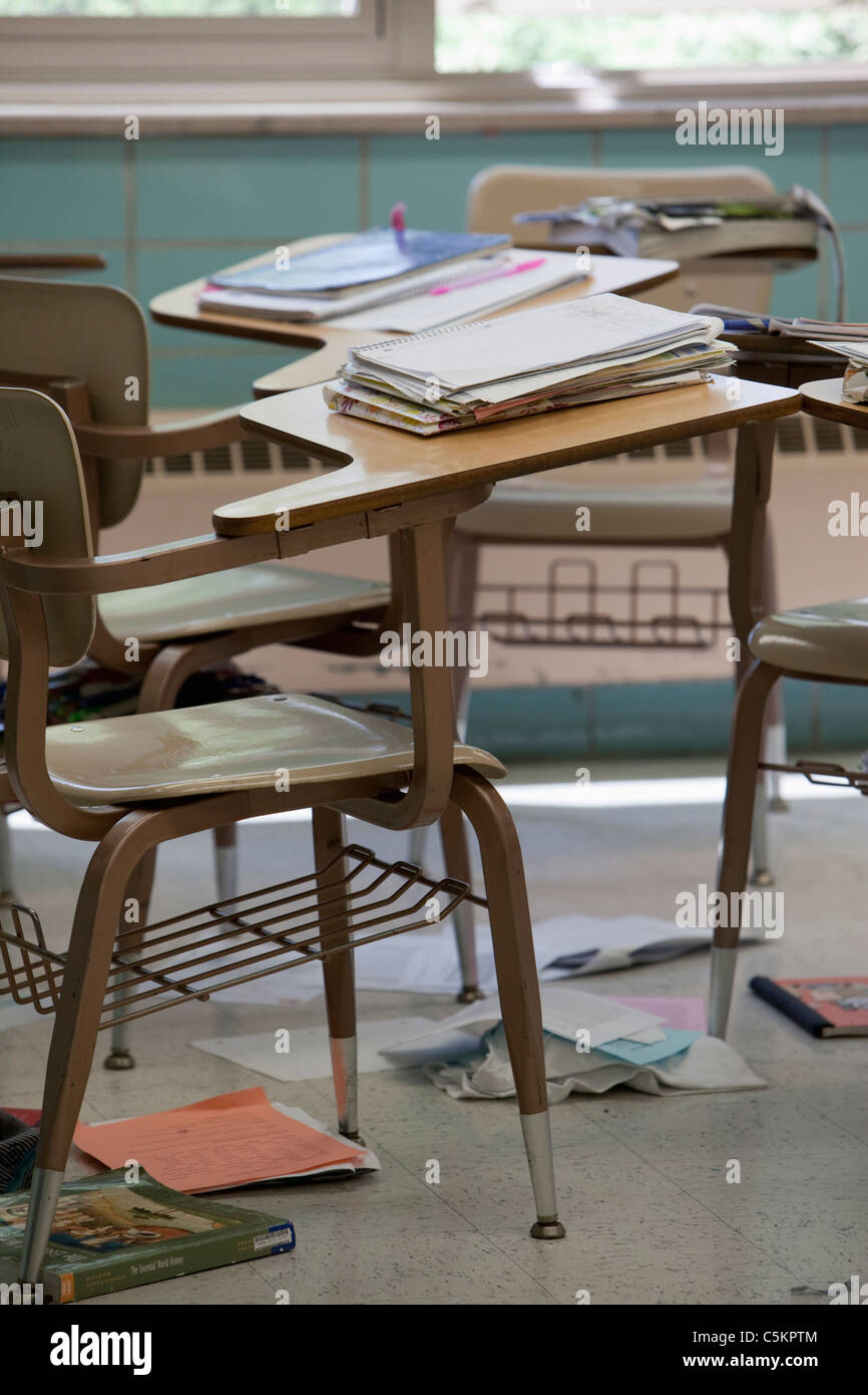 Salle de classe abandonnée d'un bureau avec des livres et des débris Banque D'Images