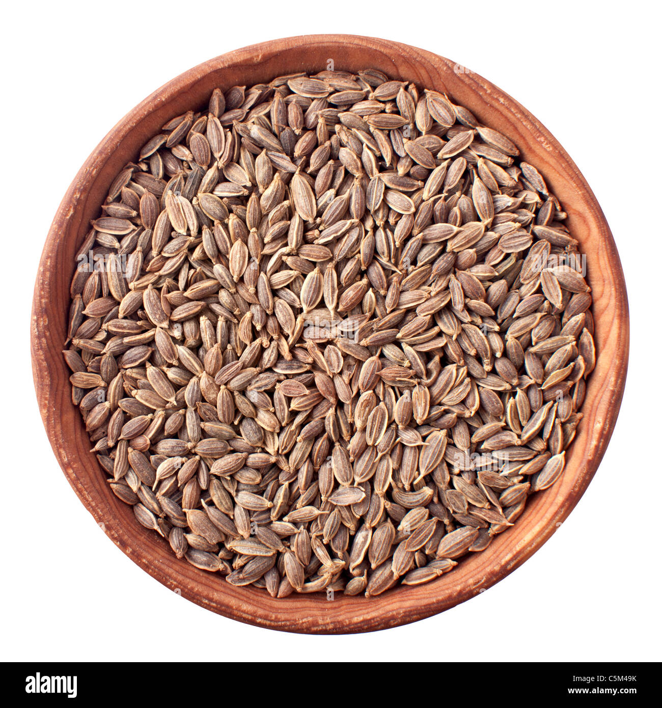 Graines d'aneth dans un bol en bois isolé sur fond blanc Banque D'Images