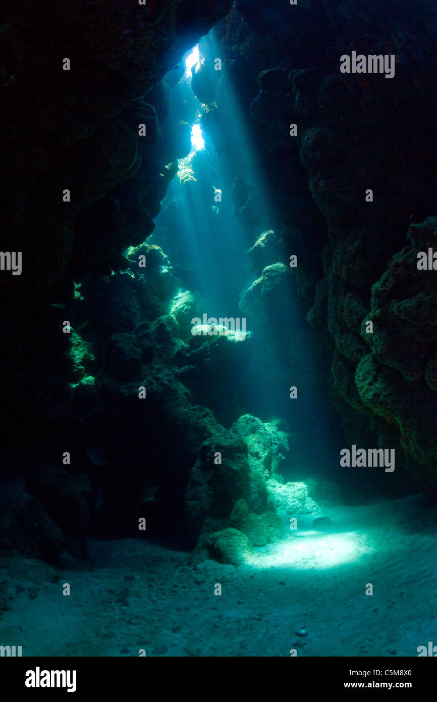 Rayons de lumière vers le bas dans une grotte sous-marine à l'ouverture des îles Swan, 90 milles au large des côtes du Honduras. Banque D'Images