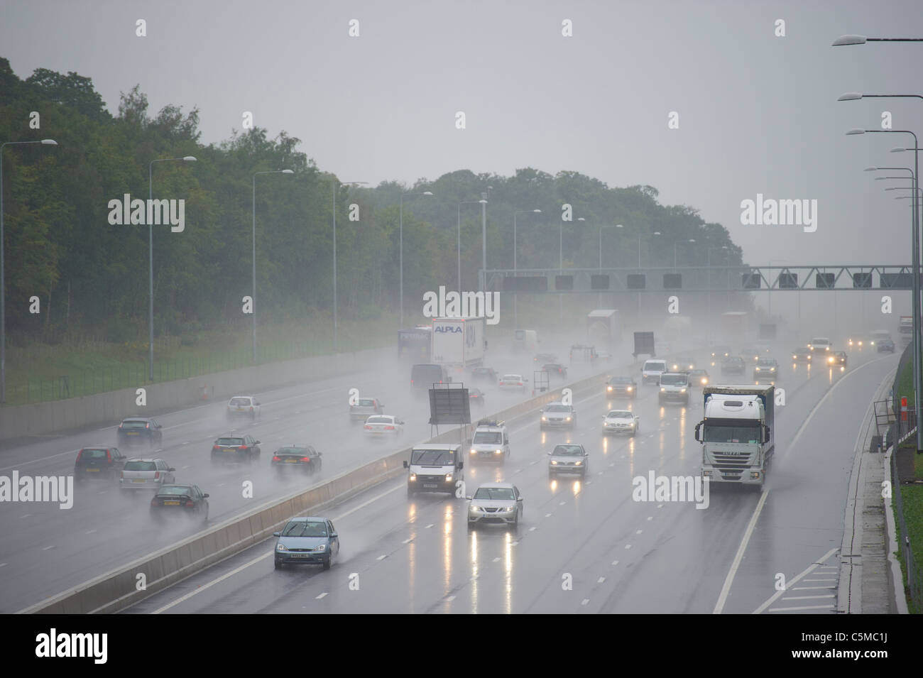 Le trafic sur le M25 dans l'Essex, lors de fortes pluies provoquant la pulvérisation et la visibilité réduite. Banque D'Images