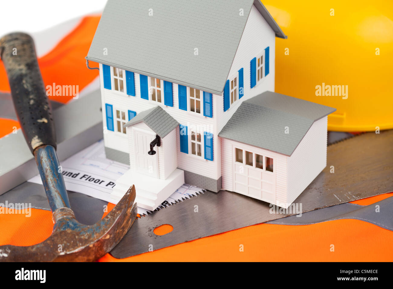 Tools and miniature house sur une veste orange Banque D'Images