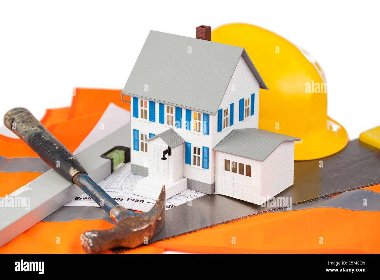 Tools and miniature house sur une veste orange Banque D'Images