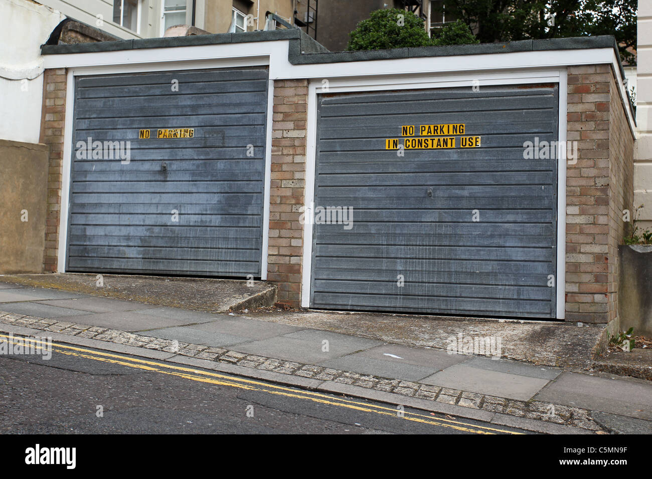 Pas de stationnement en utilisation constante des signes sur un couple de garages à Brighton, East Sussex, UK. Banque D'Images