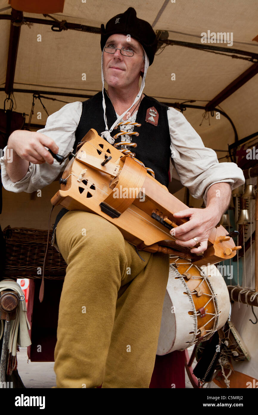 'Homme jouant de la vielle à roue" à l'assemblée annuelle du marché médiéval de Chesterfield, Derbyshire, Angleterre, RU Banque D'Images