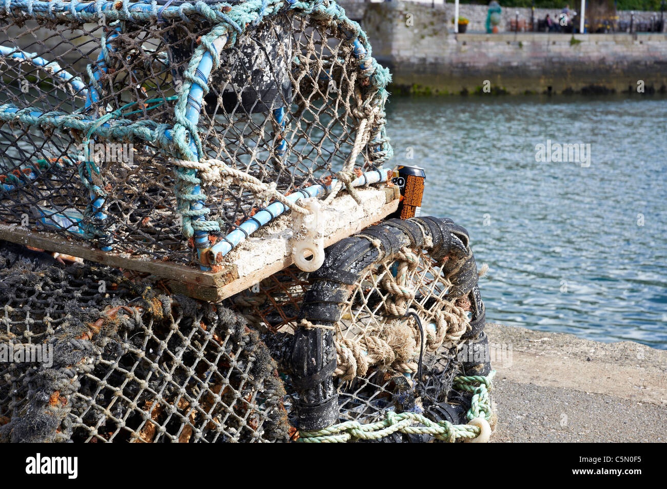 Des casiers à crabe et homard empilés sur le quai au port de Brixham Devon, Angleterre. Banque D'Images