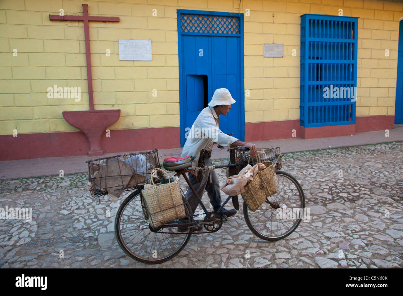 Cuba, Trinidad. Man Pushing Bicycle passé maison où Alexander Humboldt, pour qui le courant de Humboldt est nommé, a séjourné en 1801. Banque D'Images