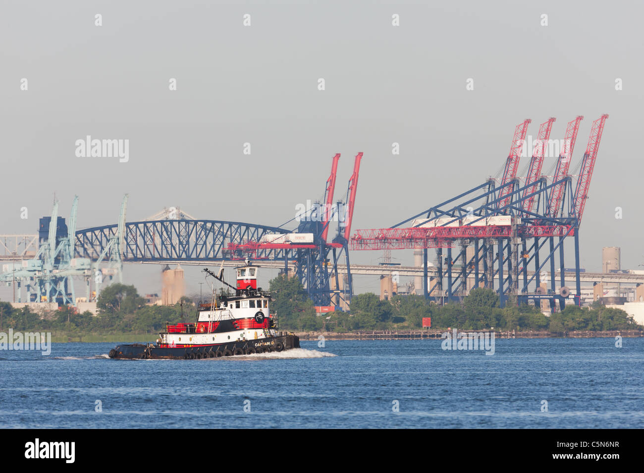 Remorqueur remorqueur Norfolk 'Captain D' dans la baie de Newark, avec le conteneur de grues le terminal à conteneurs de New York dans l'arrière-plan. Banque D'Images