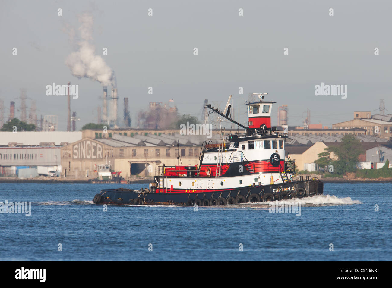 Remorqueur remorqueur Norfolk 'Captain D' à l'usine de machines à coudre Singer en arrière-plan sur la baie de Newark. Banque D'Images