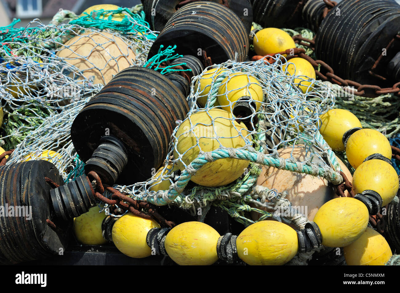 Tas de filets de pêche au chalut colorées et flotte sur le quai au port de Guilvinec, Finistère, Bretagne, France Banque D'Images