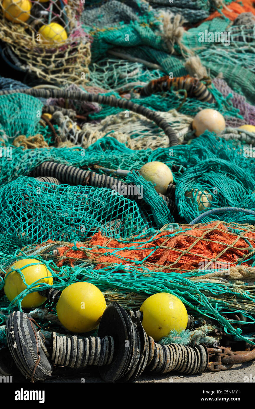 Tas de filets de pêche au chalut colorées et flotte sur le quai au port de Guilvinec, Finistère, Bretagne, France Banque D'Images