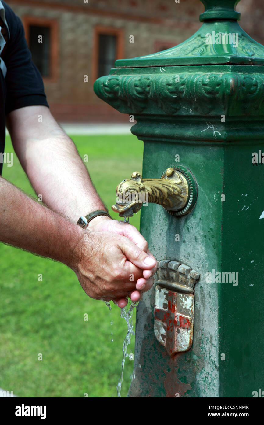 L'homme lave les mains de l'eau dans le parc du Château Sforzesco de Milan qui a les milanais armoiries sur elle Banque D'Images L'homme lave les mains de l'eau dans le parc du Château Sforzesco de Milan qui a les milanais armoiries sur elle Banque D'Images