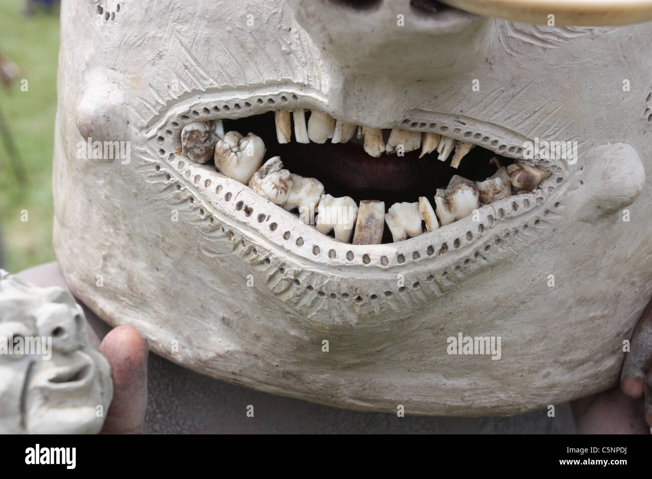 Close up d'un Asaro Mudman dans son masque et il tient une version miniature. Banque D'Images