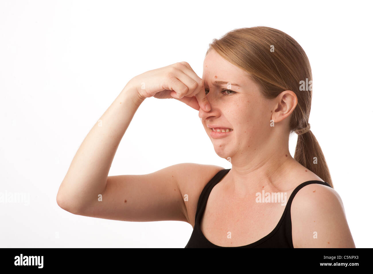 Un young caucasian woman holding her nose pour atténuer une mauvaise odeur malodorante Banque D'Images