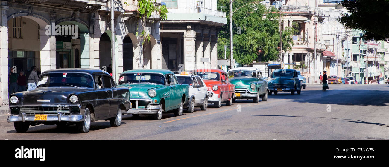 Cuba, La Havane. Voitures américaines antiques que les taxis, attendant à un feu rouge. Banque D'Images