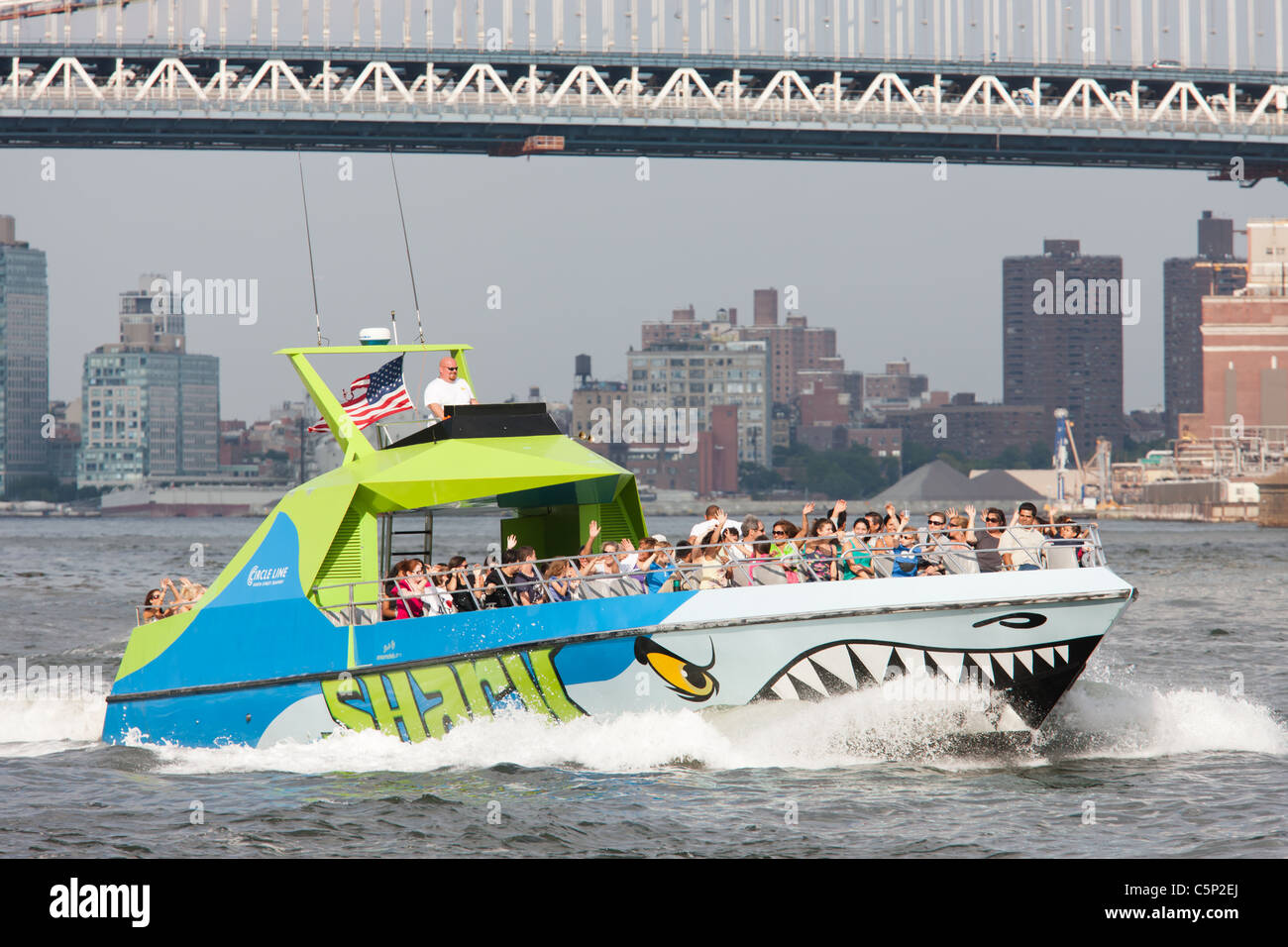 Circle Line speedboat requin sur l'East River, approche de son arrêt à South Street Seaport Pier 16 à New York City. Banque D'Images