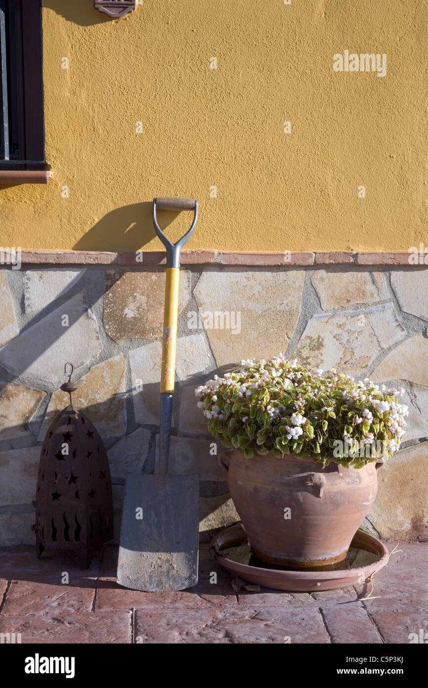 Soleil du soir casting shadows sur jardin espagnol mur et spade Banque D'Images