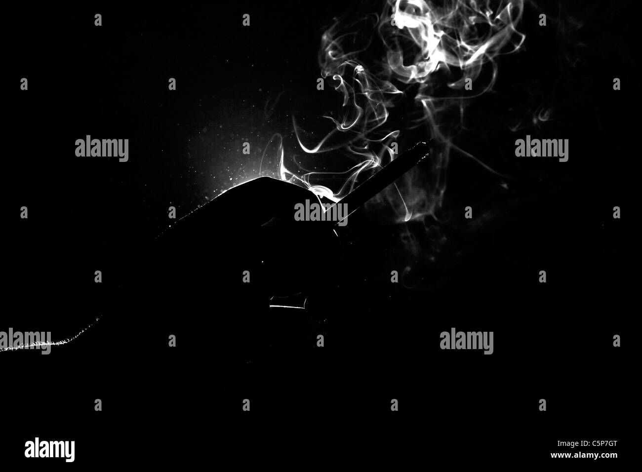Une main tenant une cigarette allumée Banque D'Images