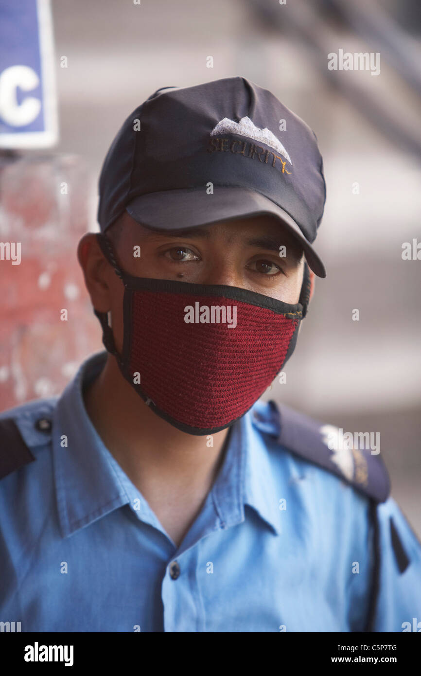 Gardien de sécurité portant un masque pour éviter la pollution, Katmandou, Népal, Asie Banque D'Images