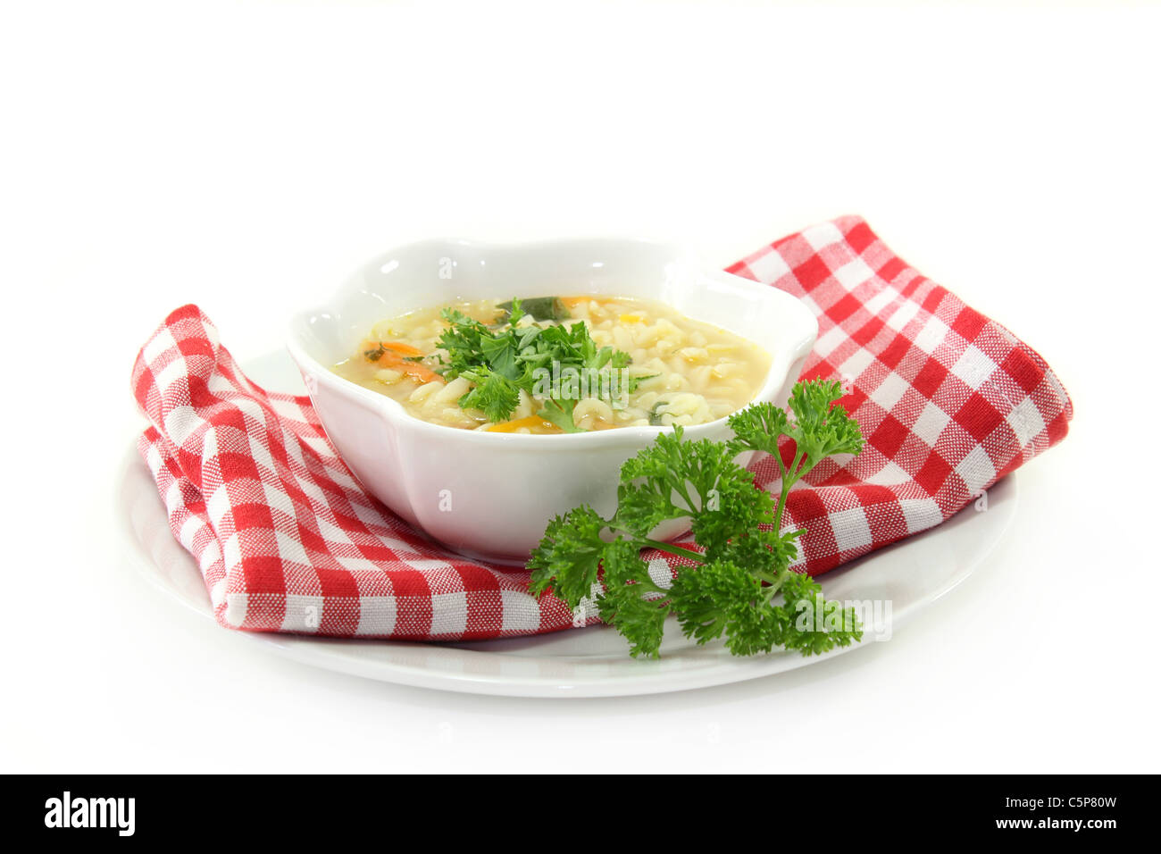 Un bol de soupe de nouilles avec des ingrédients frais et persil Banque D'Images