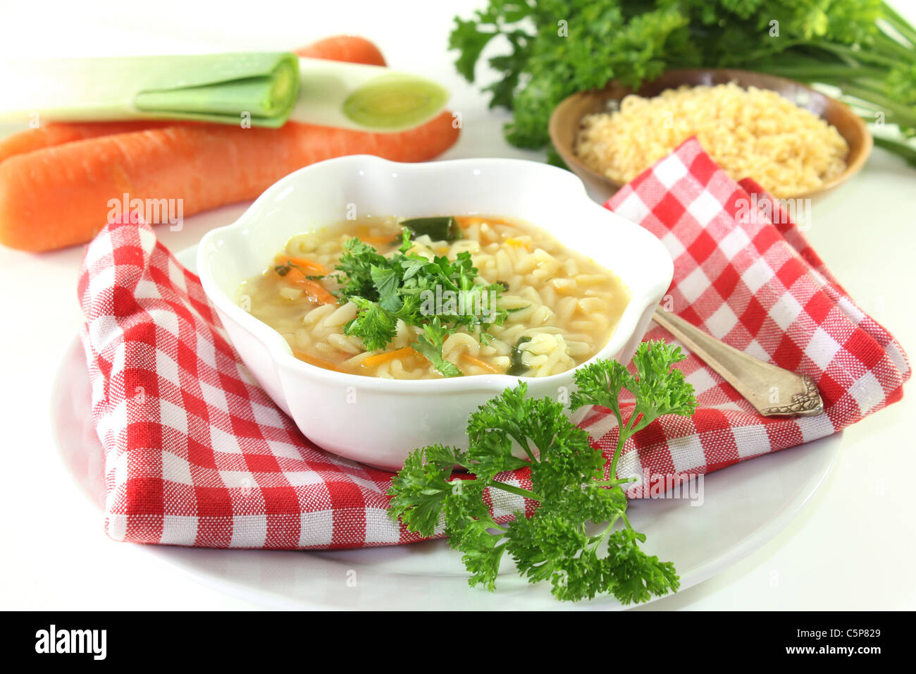 Un bol de soupe de nouilles avec des ingrédients frais et persil Banque D'Images