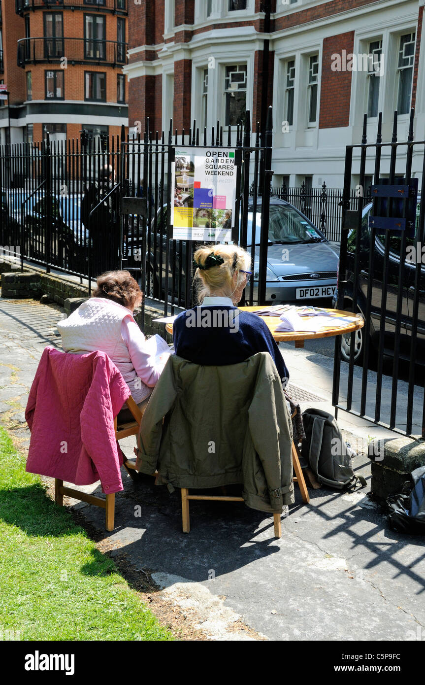 Mesdames assis à la porte de Ridgmount Gardens pendant Jardin Ouvert Squares Weekend, Bloomsbury Londres Angleterre Royaume-uni Banque D'Images