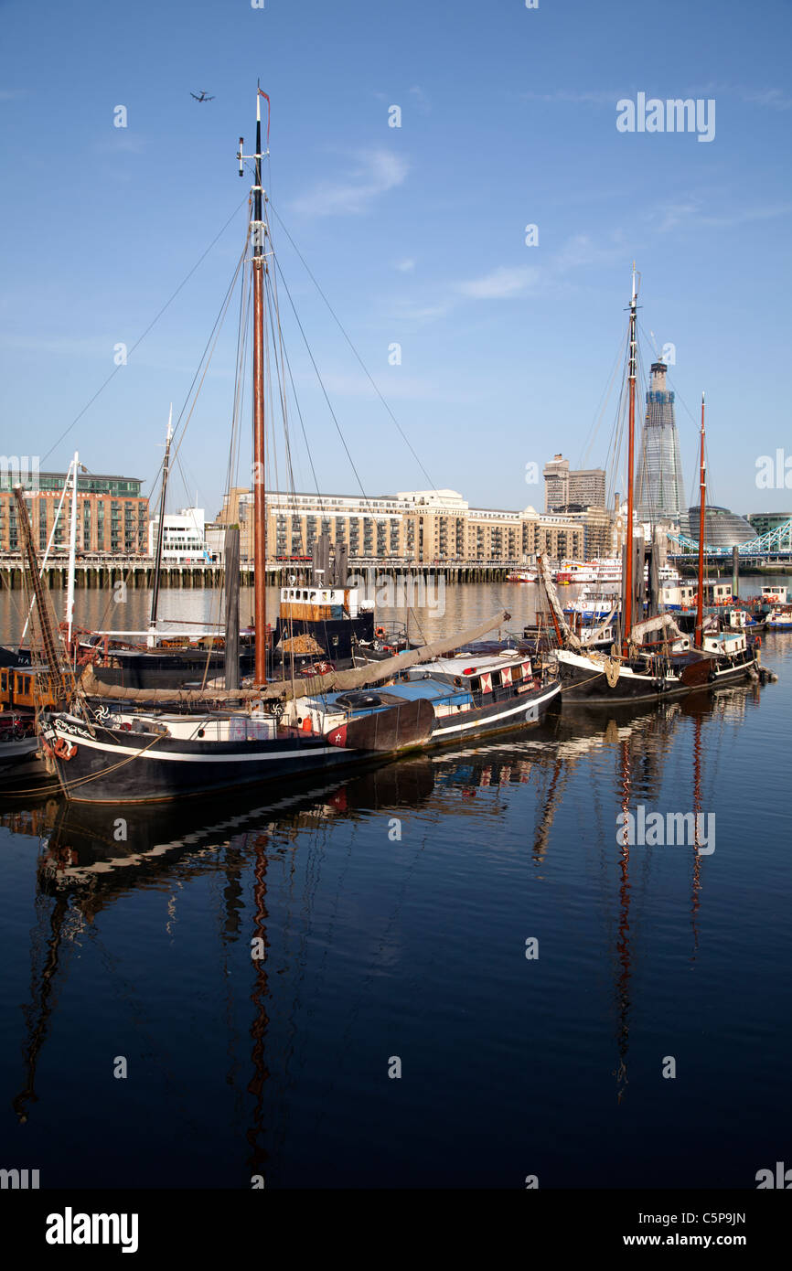Vieux bateaux amarrés à Wapping, Moorings ermitage sur la Tamise. L'Écharde de Londres en arrière-plan. Banque D'Images