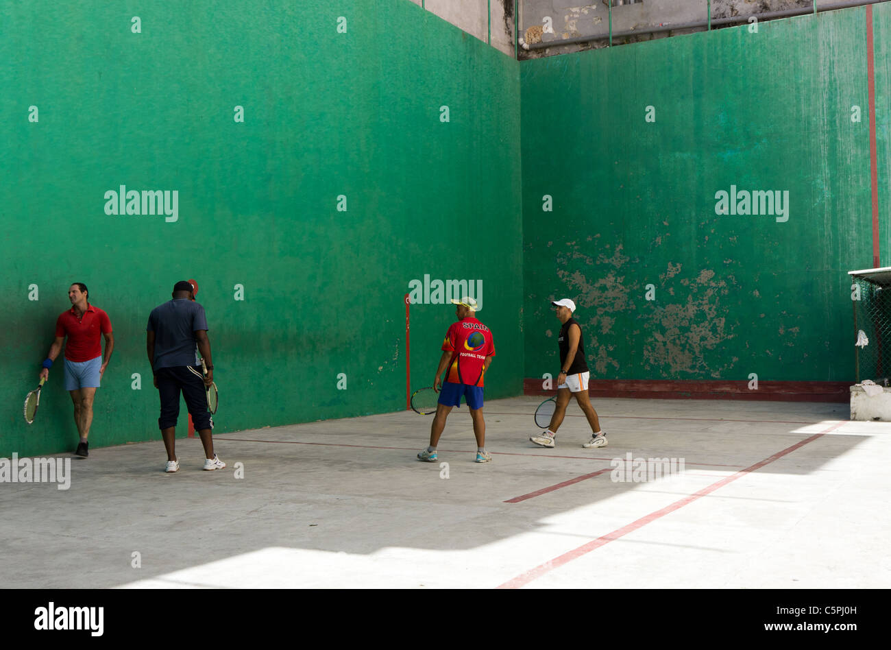 Quatre hommes jouer racquetball dans une cour en plein air à La Havane, Cuba Banque D'Images