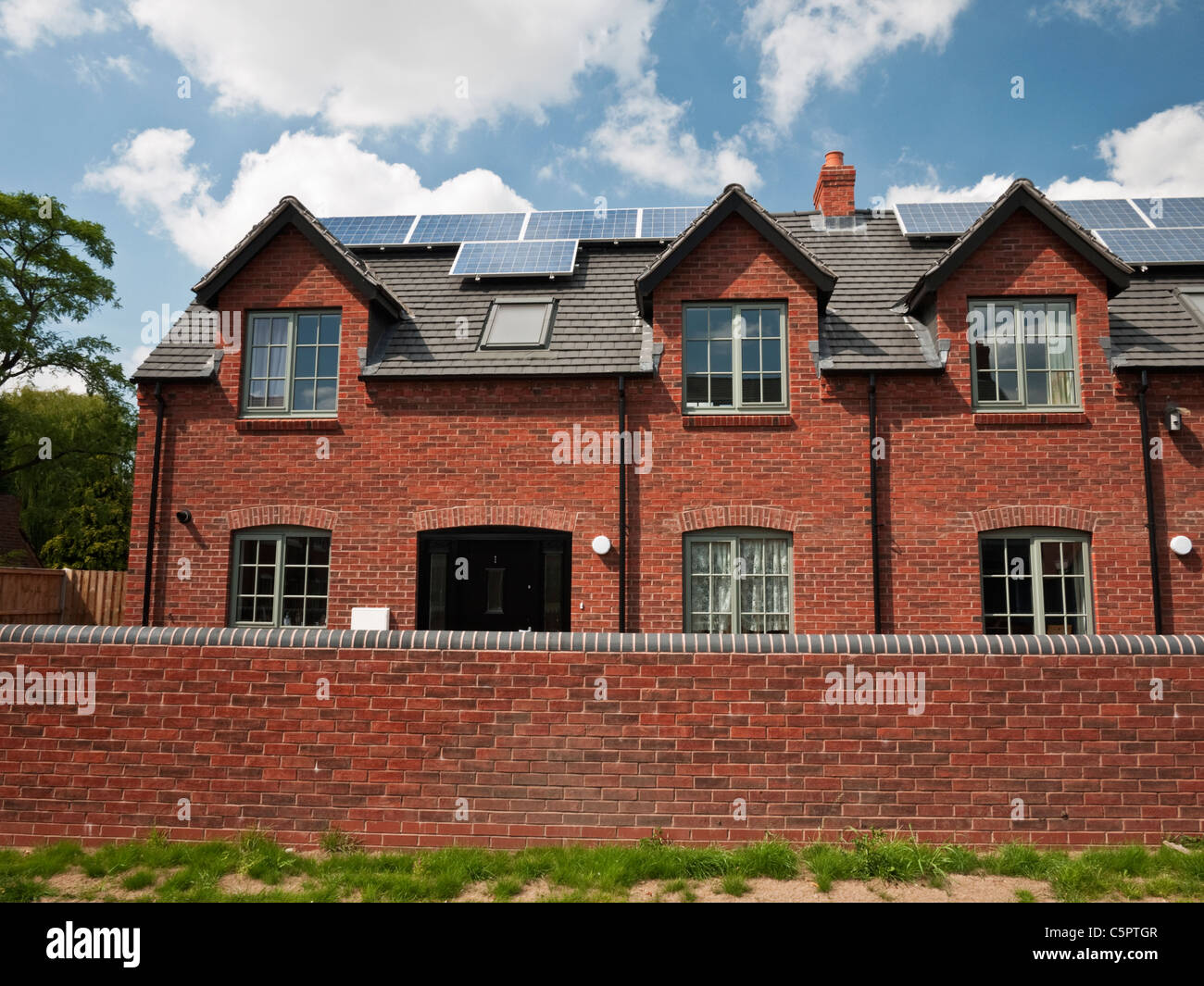 PV solaire panneaux montés sur un développement de nouveaux logements dans le village de Swindon South Staffordshire Banque D'Images