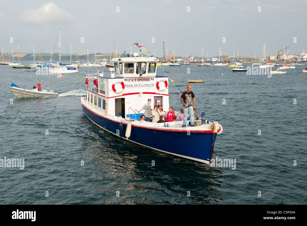 Un petit bateau de tourisme retourne à quai dans le port de Falmouth après un tour du quai. (Usage éditorial uniquement). Banque D'Images