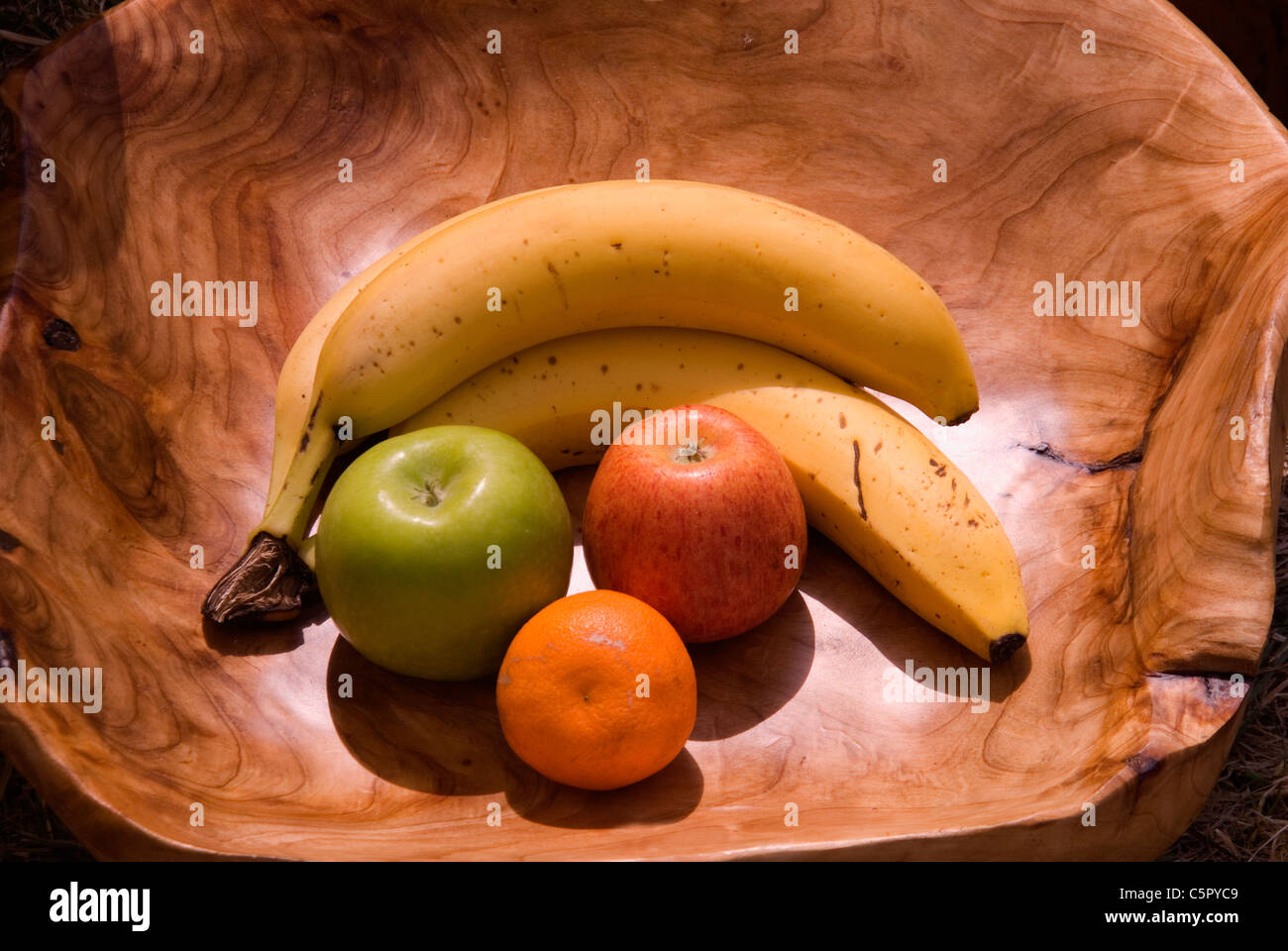Une sélection de fruits dans un bol en bois sculpté à la main Banque D'Images