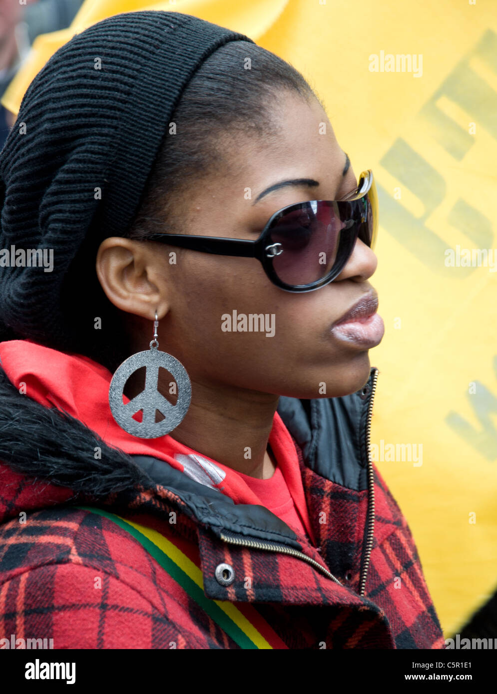 Femme noire avec des lunettes de soleil et de grandes boucles d'CND au G20 mars à Londres Banque D'Images