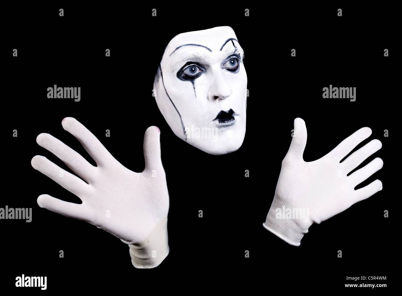 Mime le visage et les mains en gants blancs et une composition théâtrale isolé sur fond noir Banque D'Images