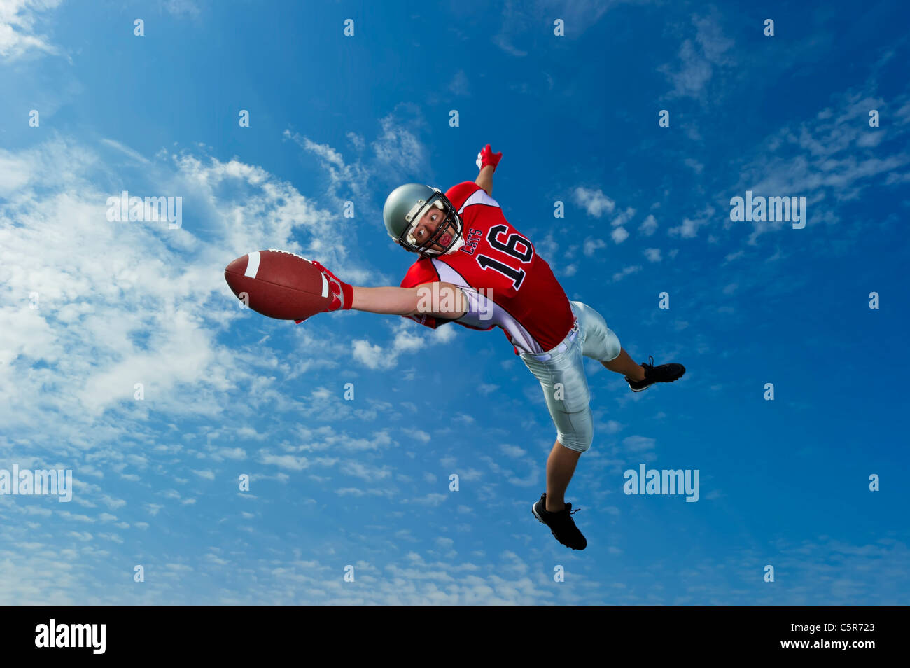 Footballeur américain dans les airs s'étend pour faire la capture. Banque D'Images