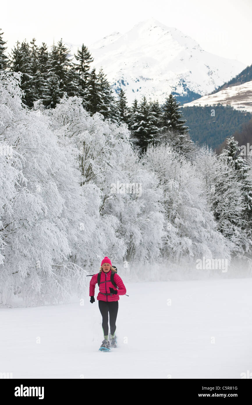 Une femme la raquette à neige à l'hiver les montagnes. Banque D'Images
