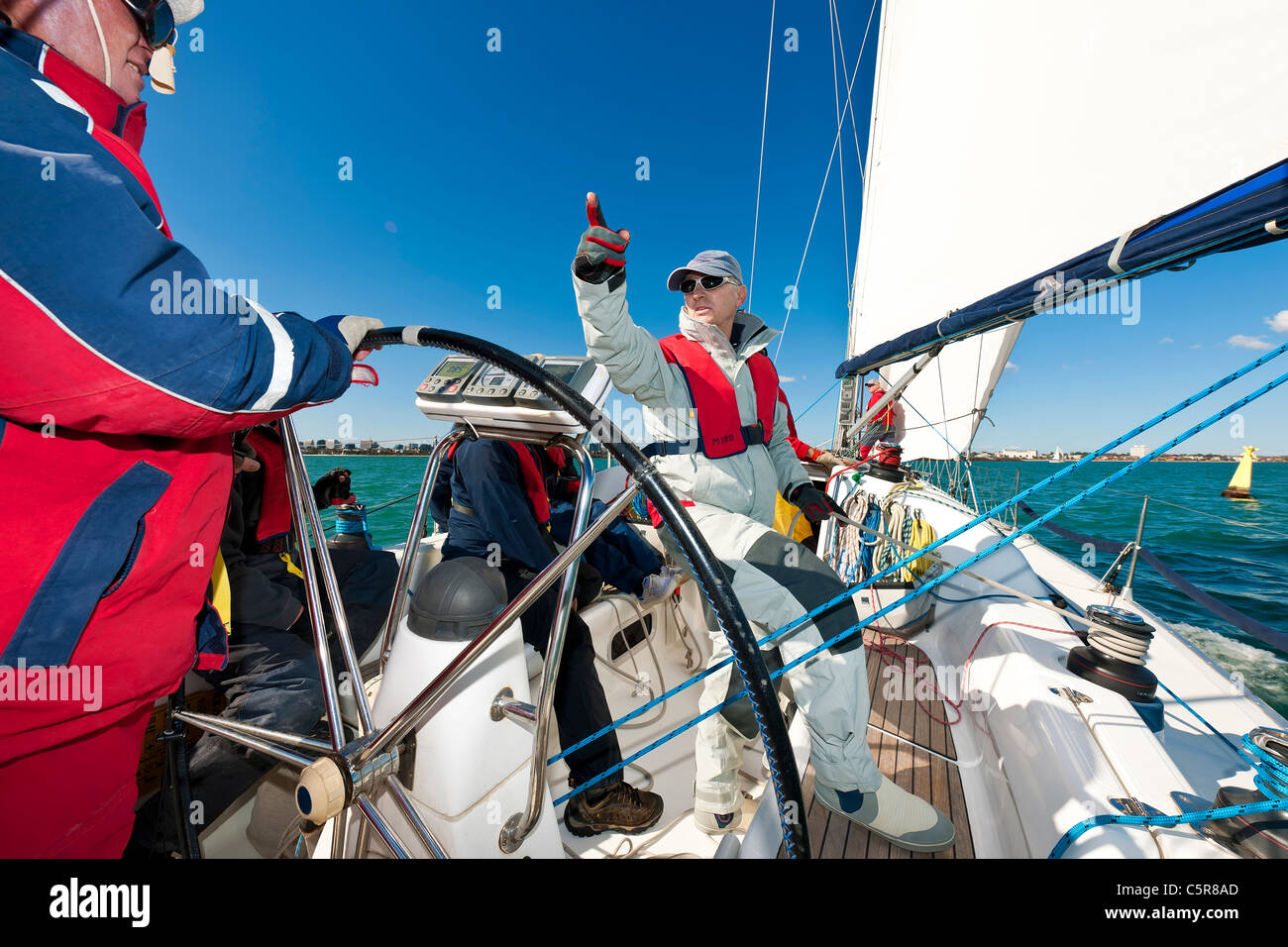 L'équipage d'un Yacht au large des côtes se prépare à la race. Banque D'Images