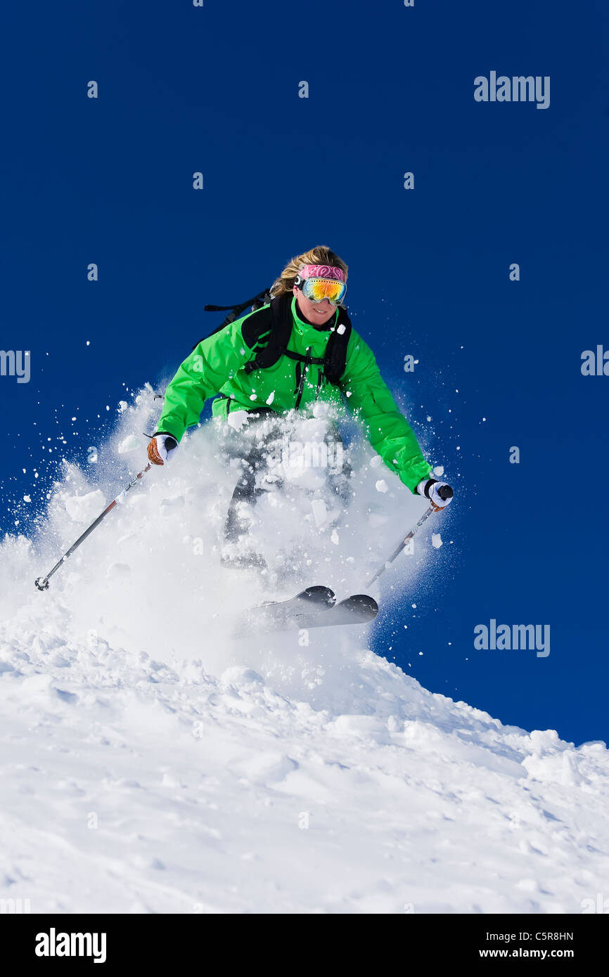 Un skieur skis féminins à travers rapide la neige de printemps. Banque D'Images