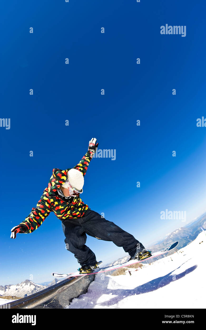Un surfeur glisse un rail dans un snow park Banque D'Images