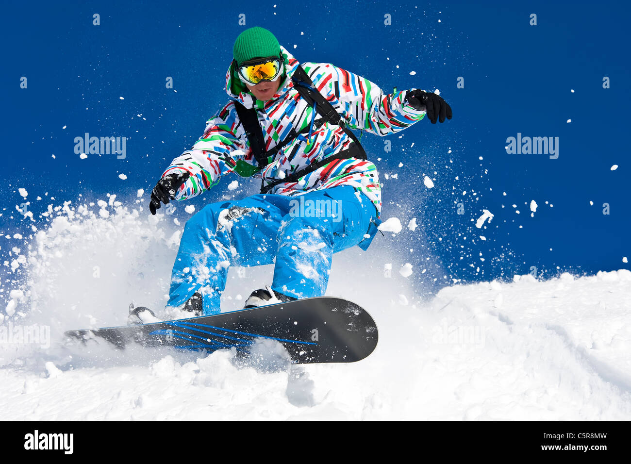 Un snowboarder riding disque hors piste à travers la neige. Banque D'Images