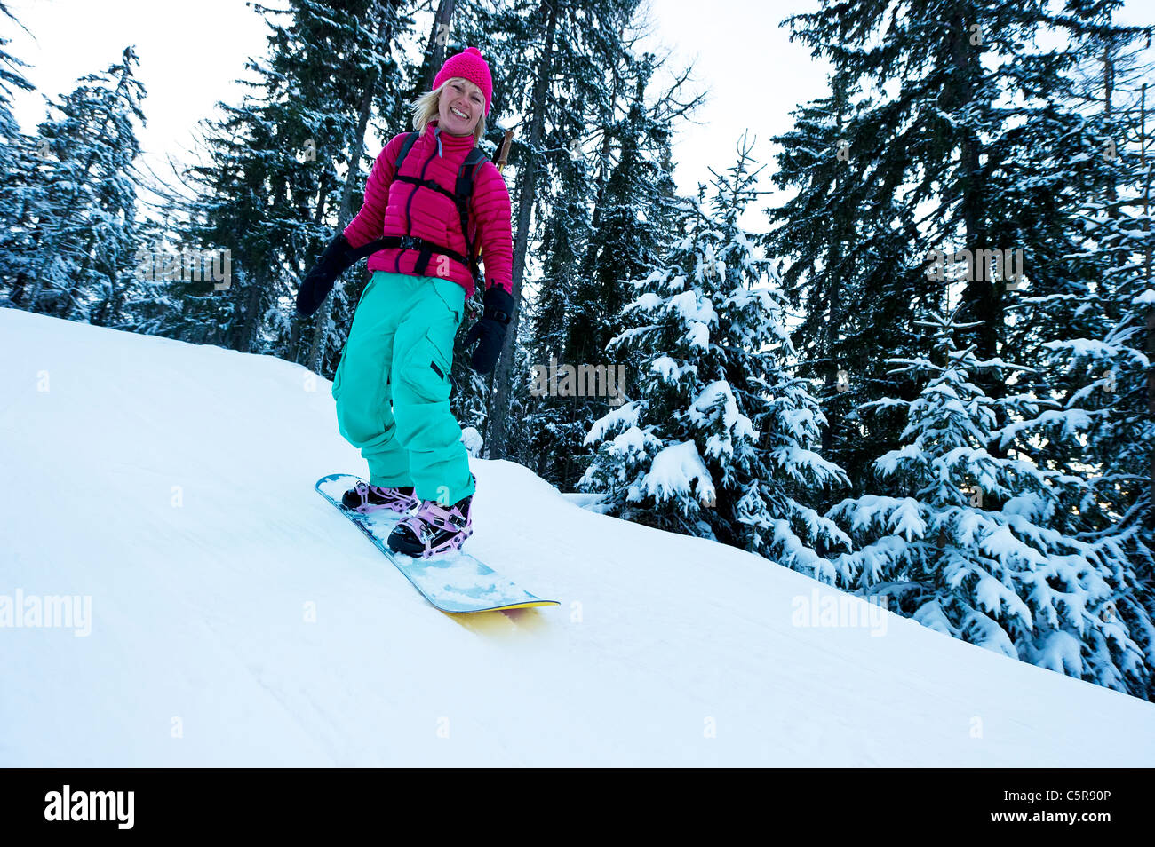 Un snowboarder balade en forêt d'hiver enneigé. Banque D'Images