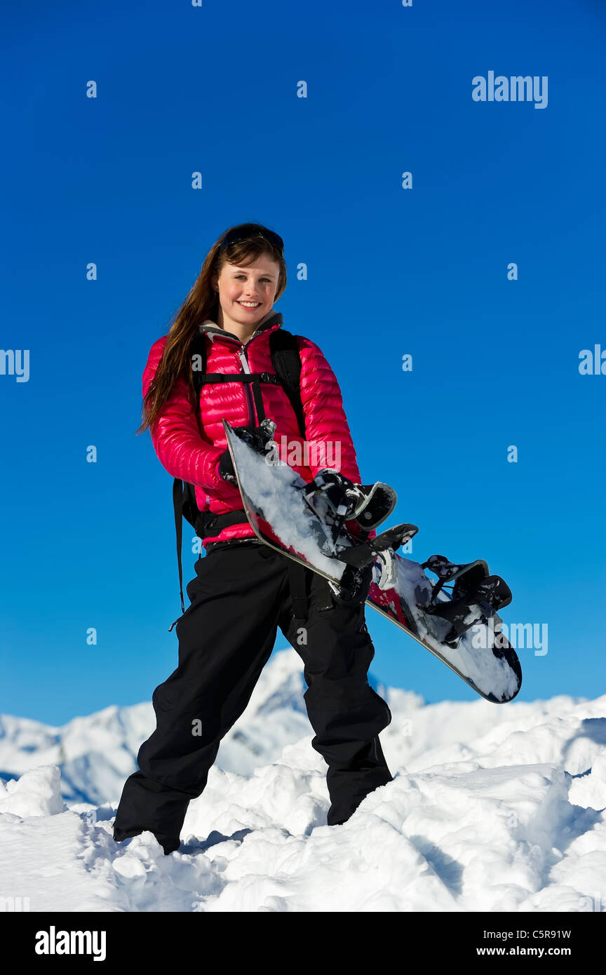 Un snowboarder s'amusant dans les montagnes enneigées. Banque D'Images